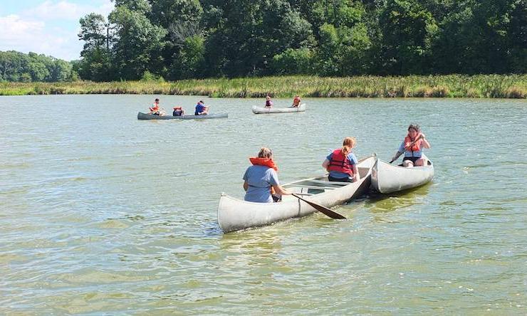 people in canoes on lake